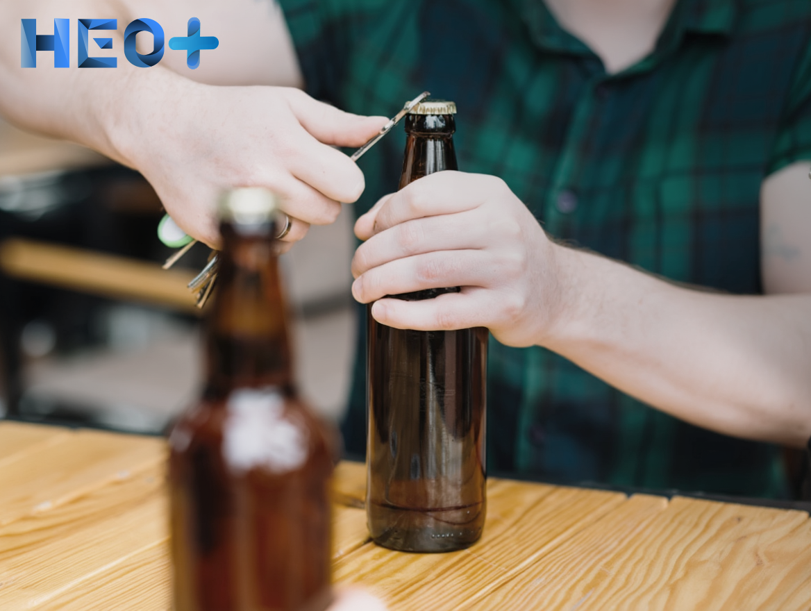 Парень открывает бутылку пива ключами